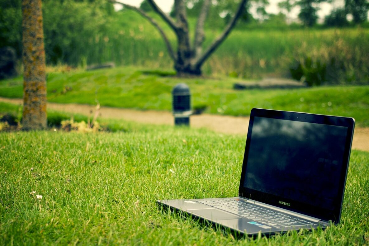 A laptop sitting on the grass.