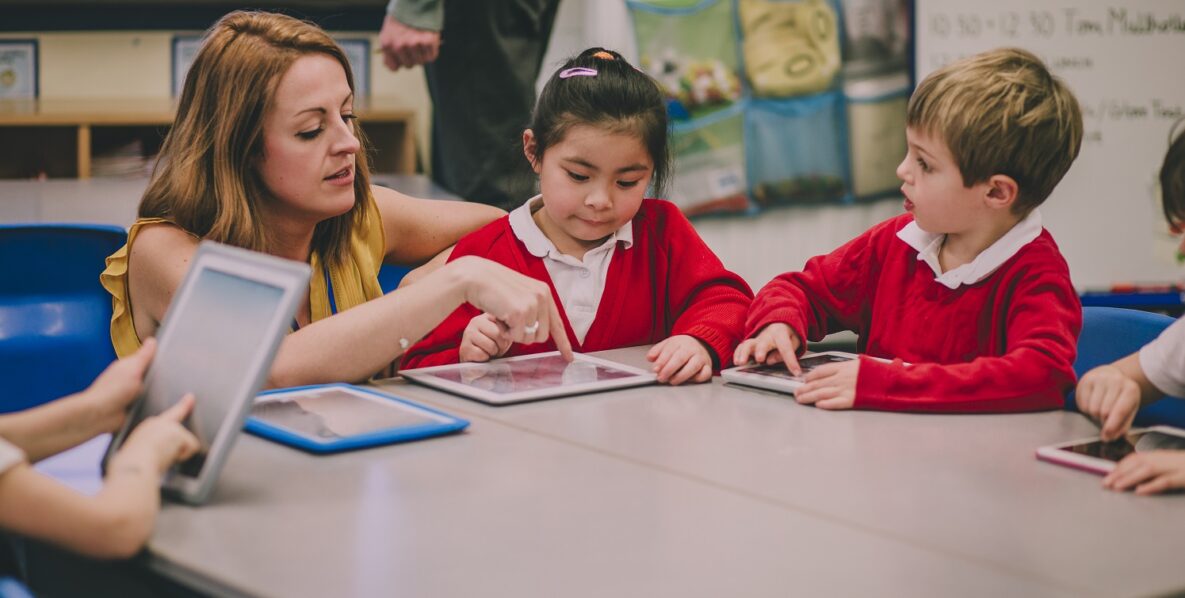 A teacher helping young students.