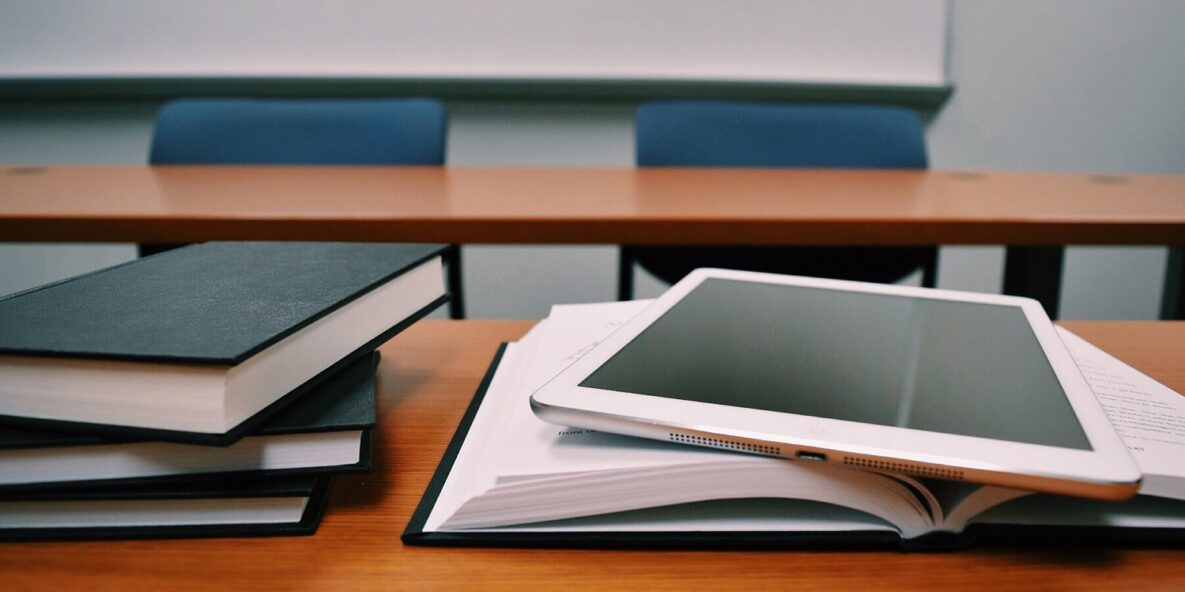 A tablet and a stack of books in the classroom.