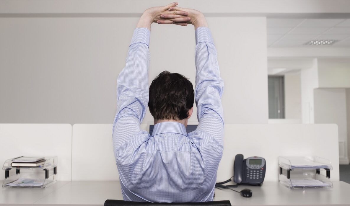 A man stretching in the office.