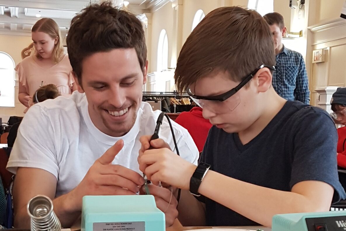 An engineer helping a student build a LipSync.