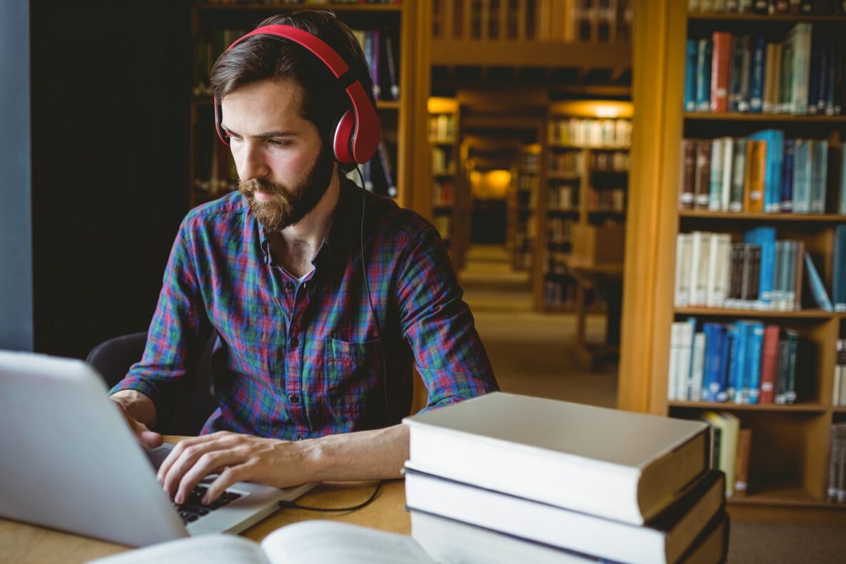 A man using a laptop to study with headphones.