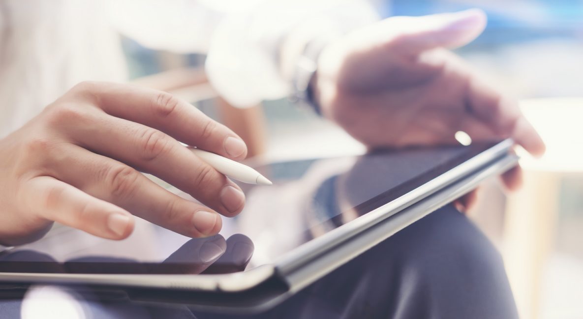 A close-up of a man using a tablet.