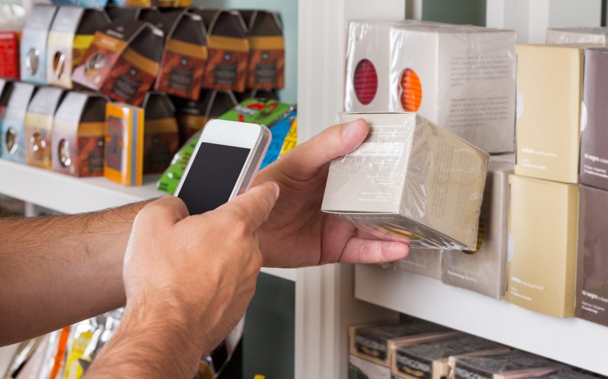A man using a smartphone to scan a label.