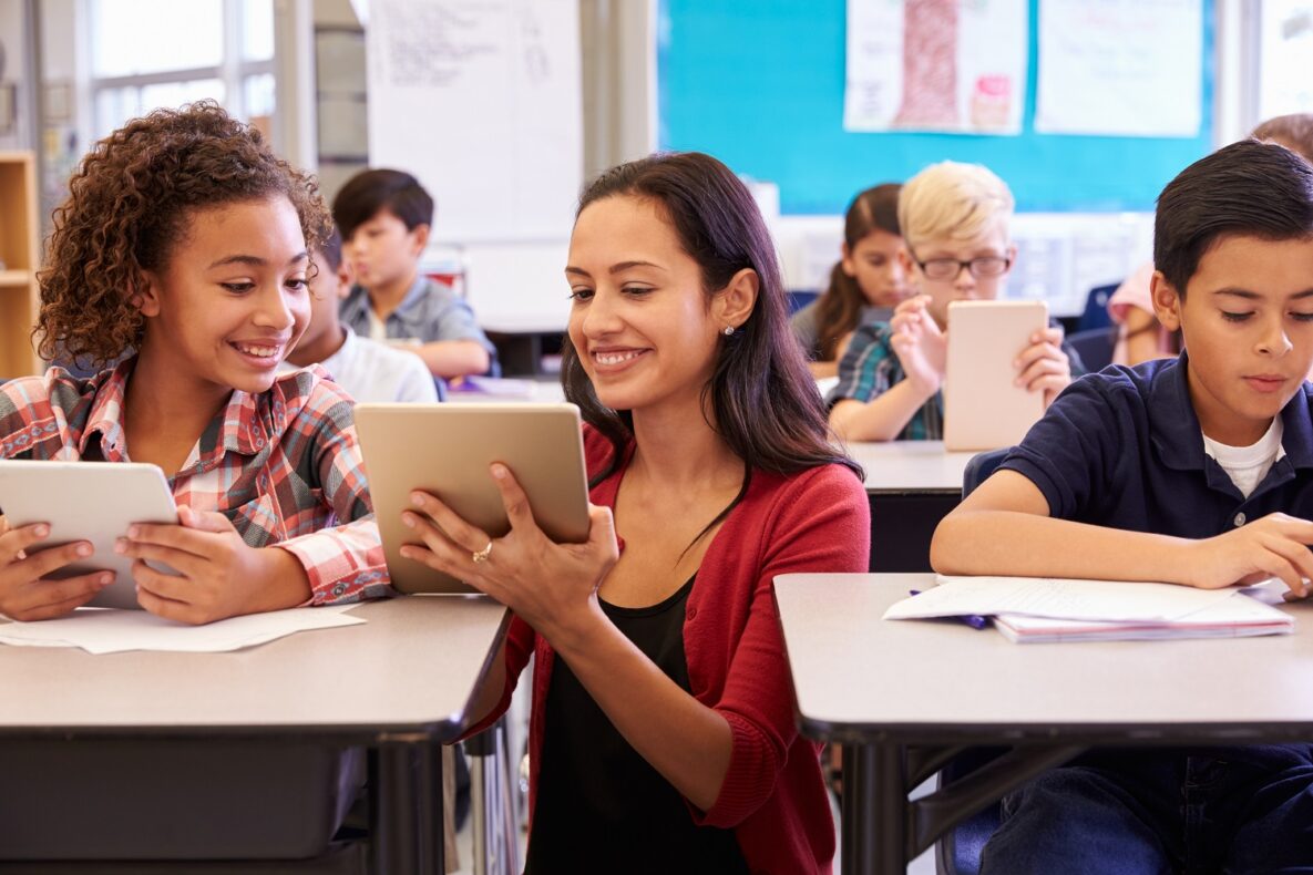 A teacher helping her student with their iPad.