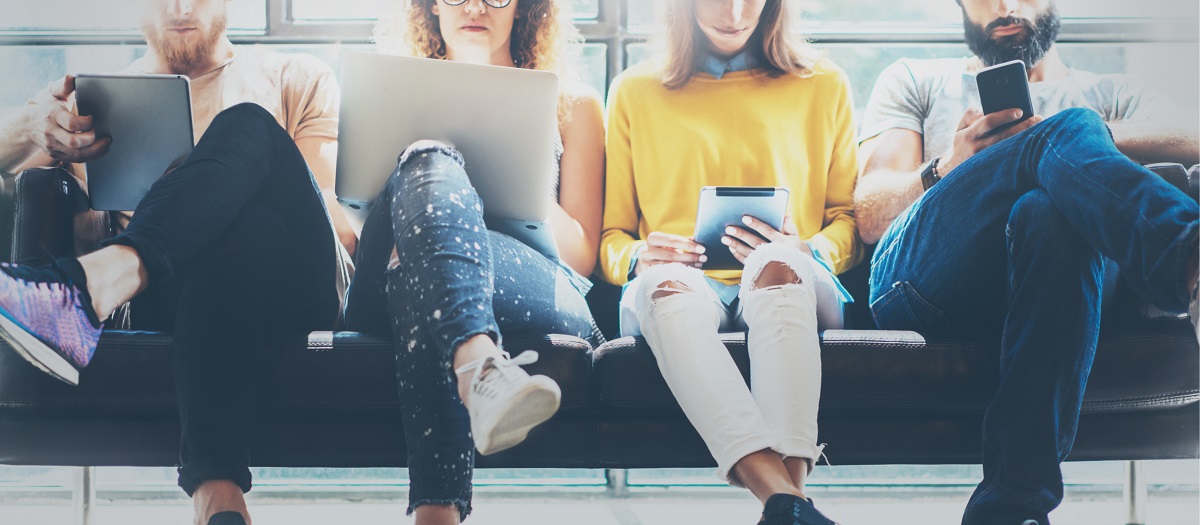A group of adults sitting together using technology.