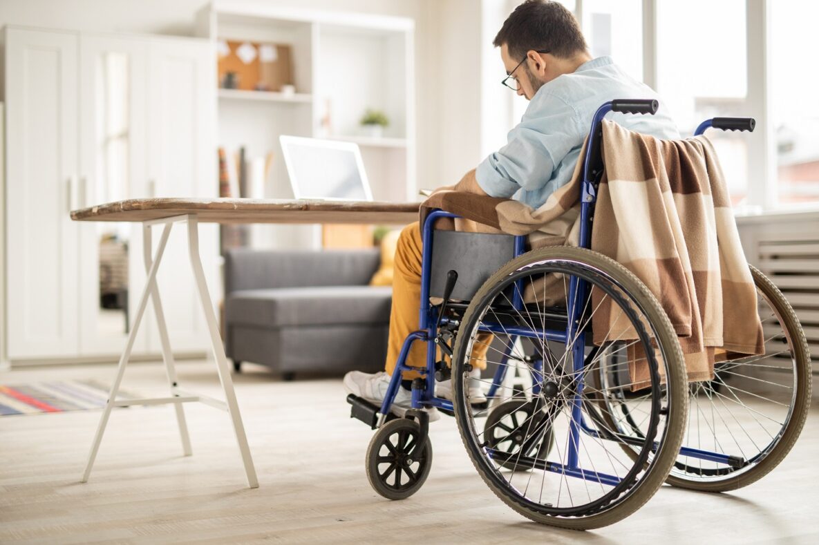 A man in a wheelchair sitting in his house.