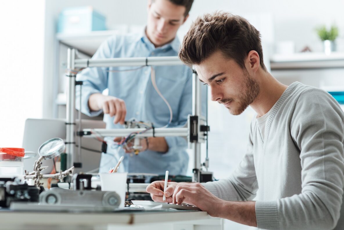 Two men working on a 3D printer.