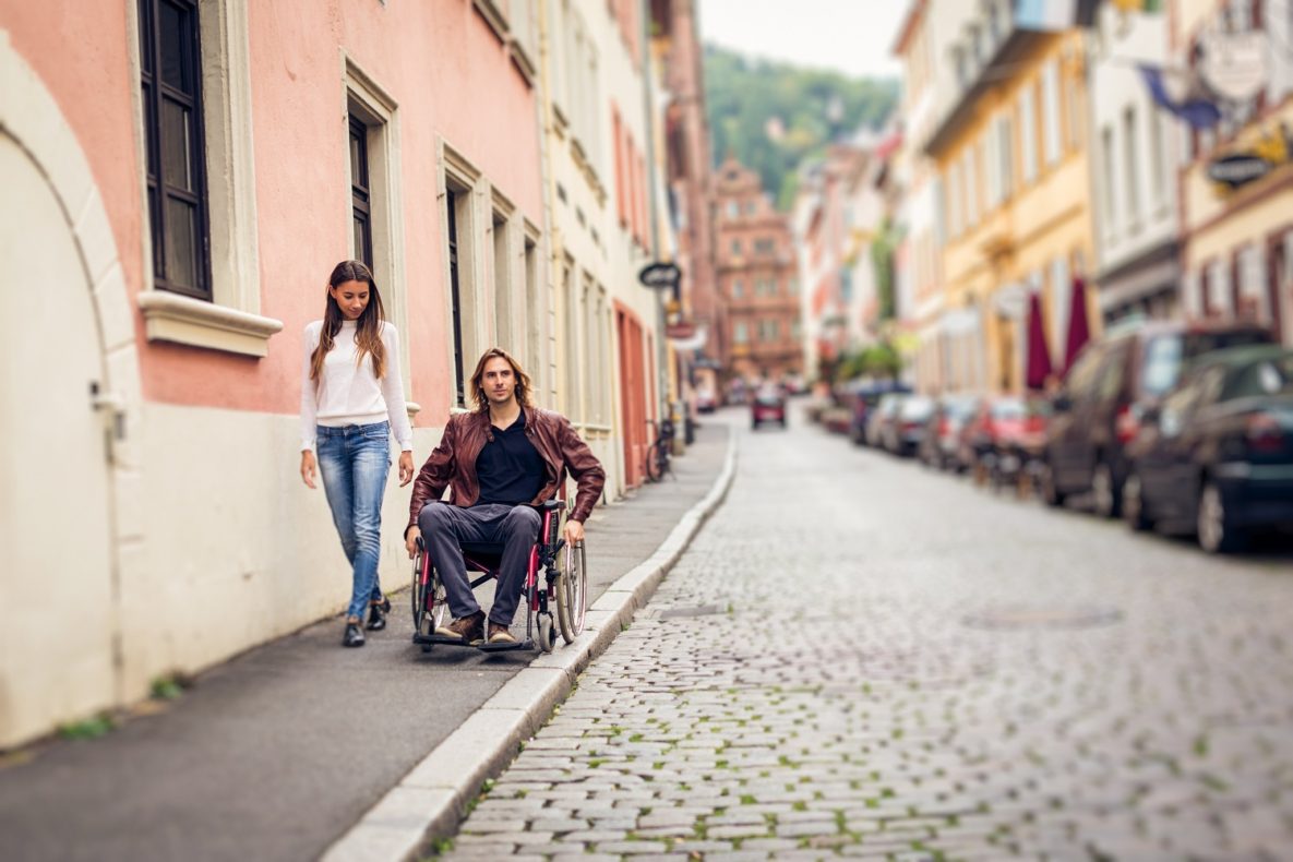 A man in a wheelchair on the street.