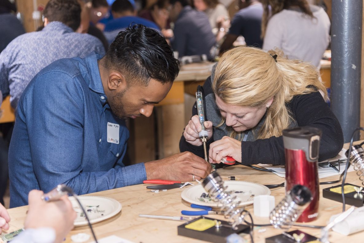 Two people working on a LipSync device.