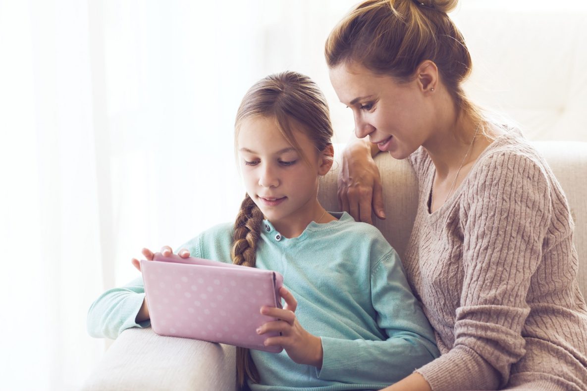 A woman and her daughter learning on a tablet.