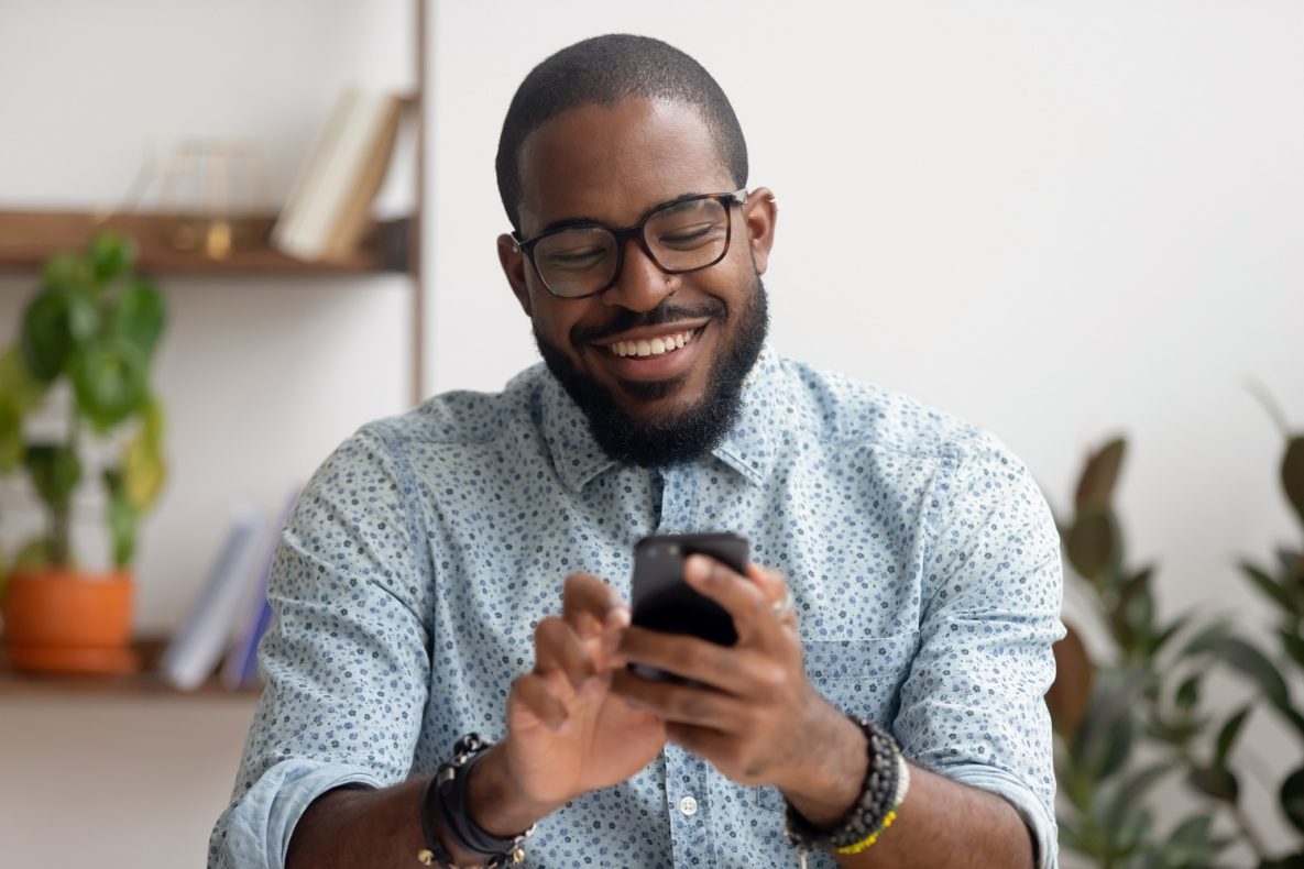 A smiling businessman using his smartphone.