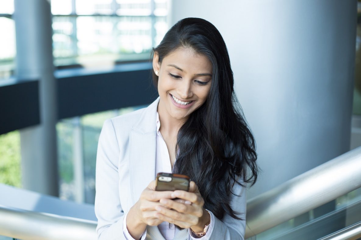A professional woman using a smartphone.