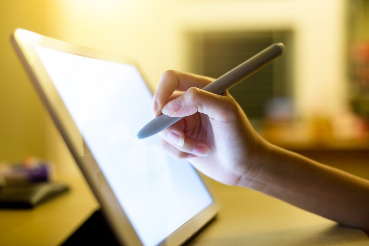 A person using a stylus on a tablet.