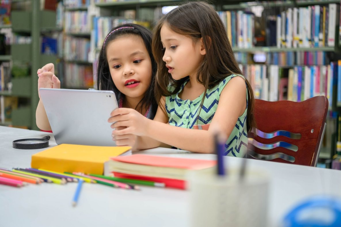 Two girls using their tablet.