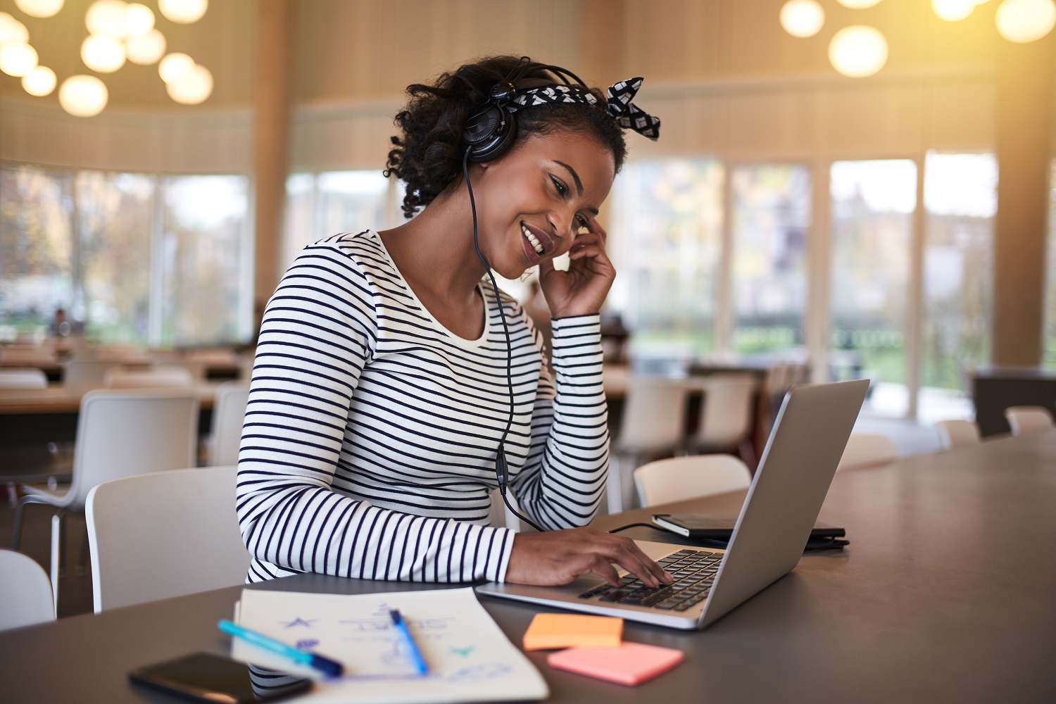 A woman using a laptop with headphones on