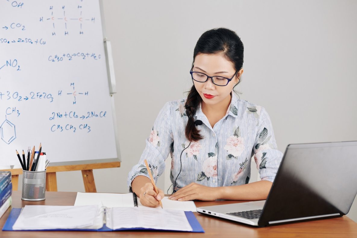 A teacher planning lessons on her laptop.