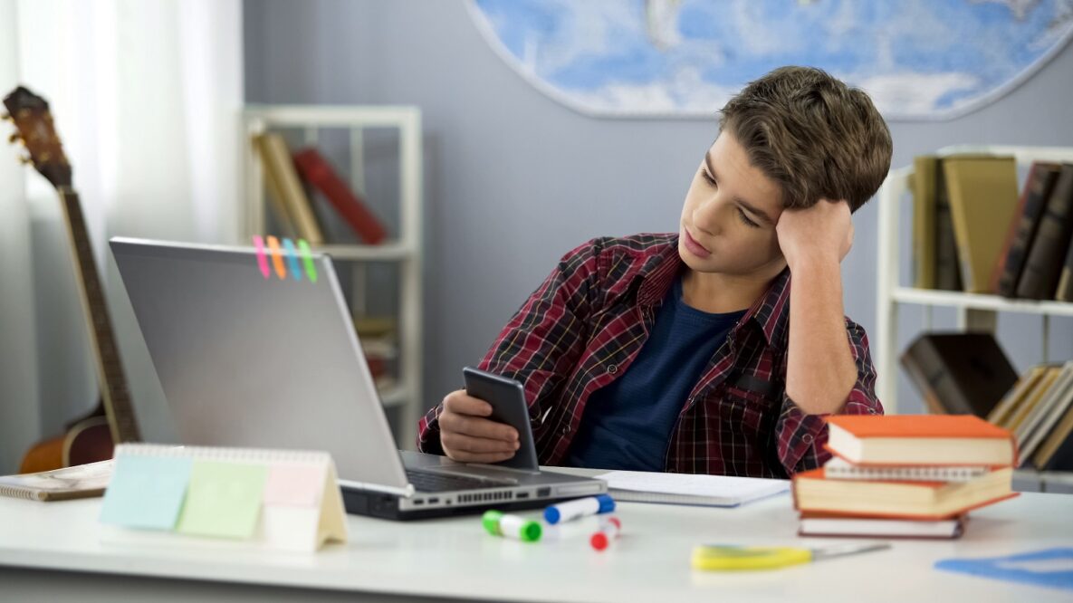 A man using a smartphone while studying.