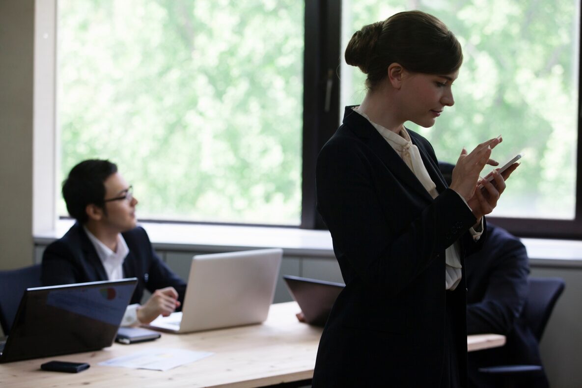 A businessperson using their smartphone in a meeting.