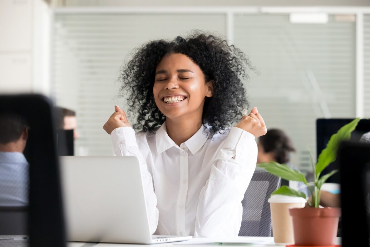 An excited woman at her desk.