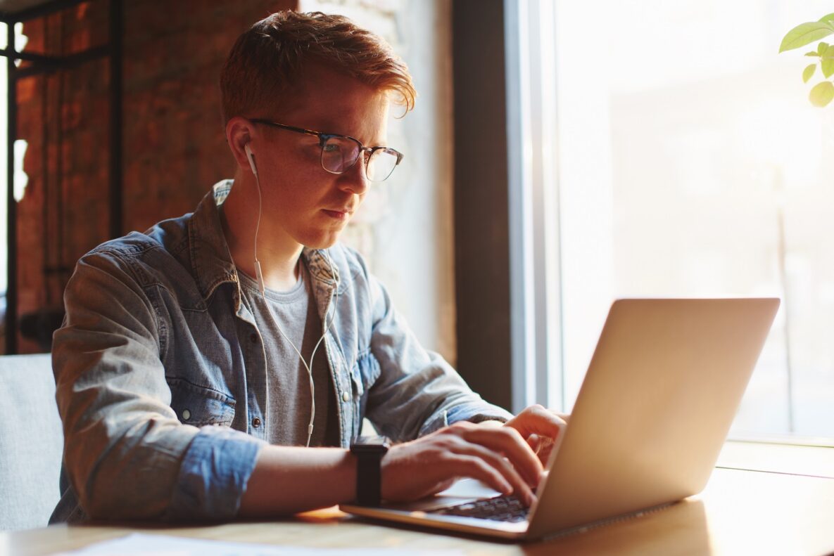 A young man typing on his laptop.