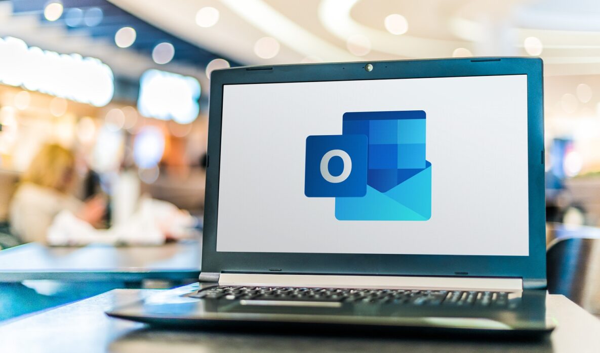 A close-up of a laptop running Outlook in the background.