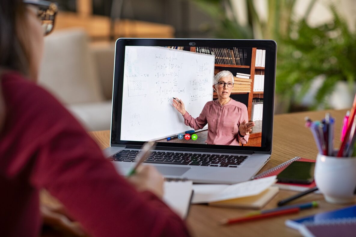 A student watching a video lesson through their laptop.