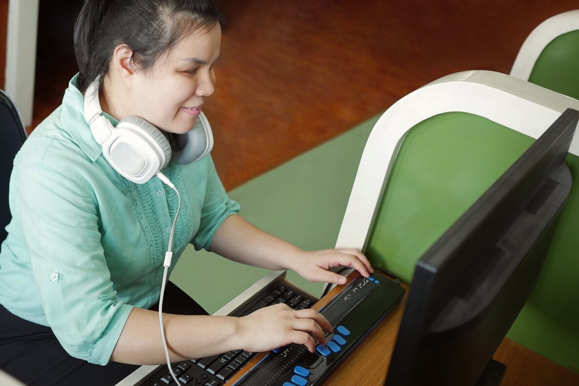 A blind woman using a braille keyboard.
