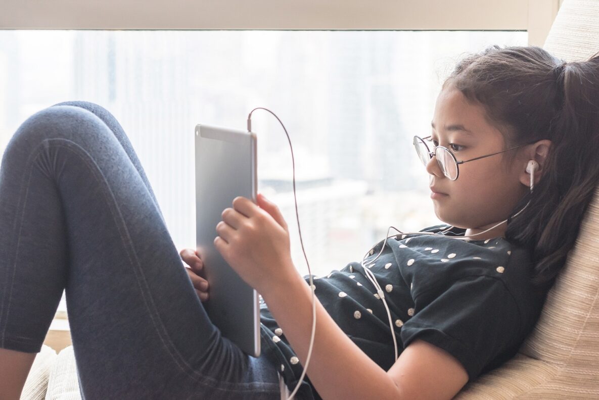 A young girl using her tablet to study.