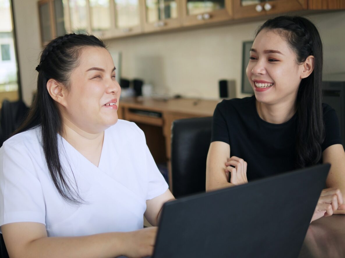 Two women working on a laptop.