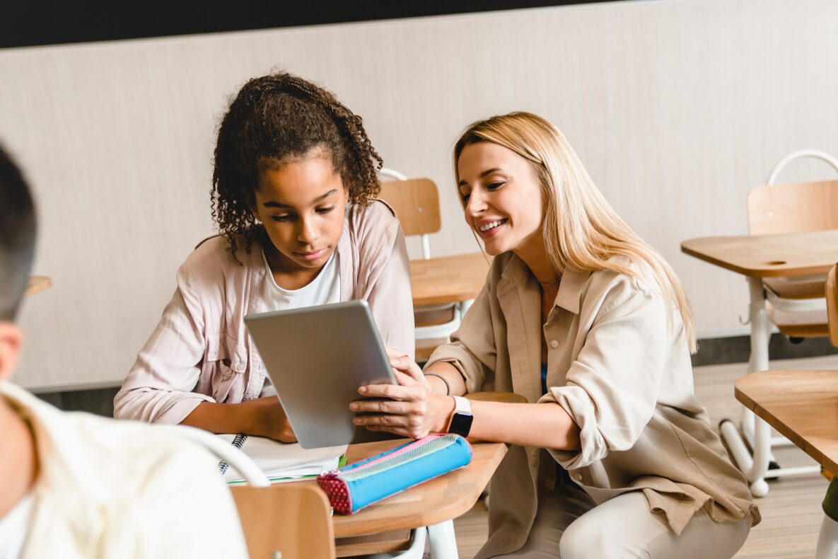 A teacher and her student using a tablet in class.
