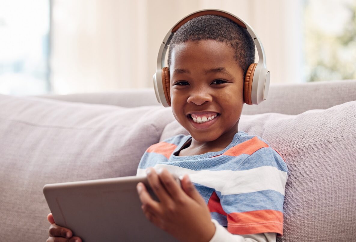 Shot of a little boy using a digital tablet while relaxing at home.