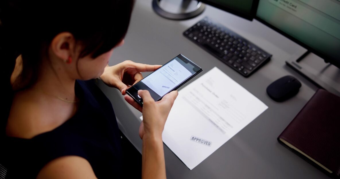 A person using their smartphone to scan a document.