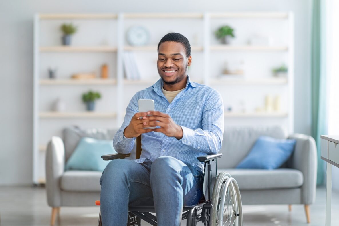 Disabled man in wheelchair using smartphone.