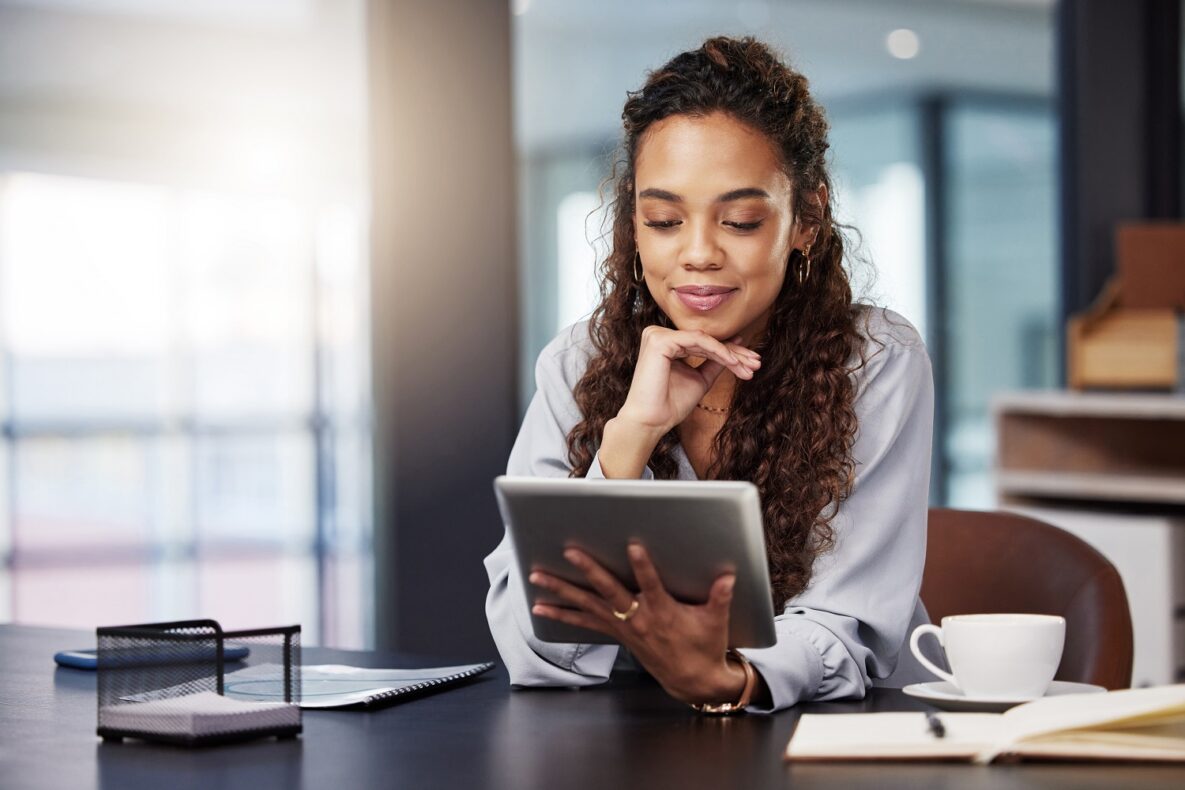 A young woman using her iPad at work.