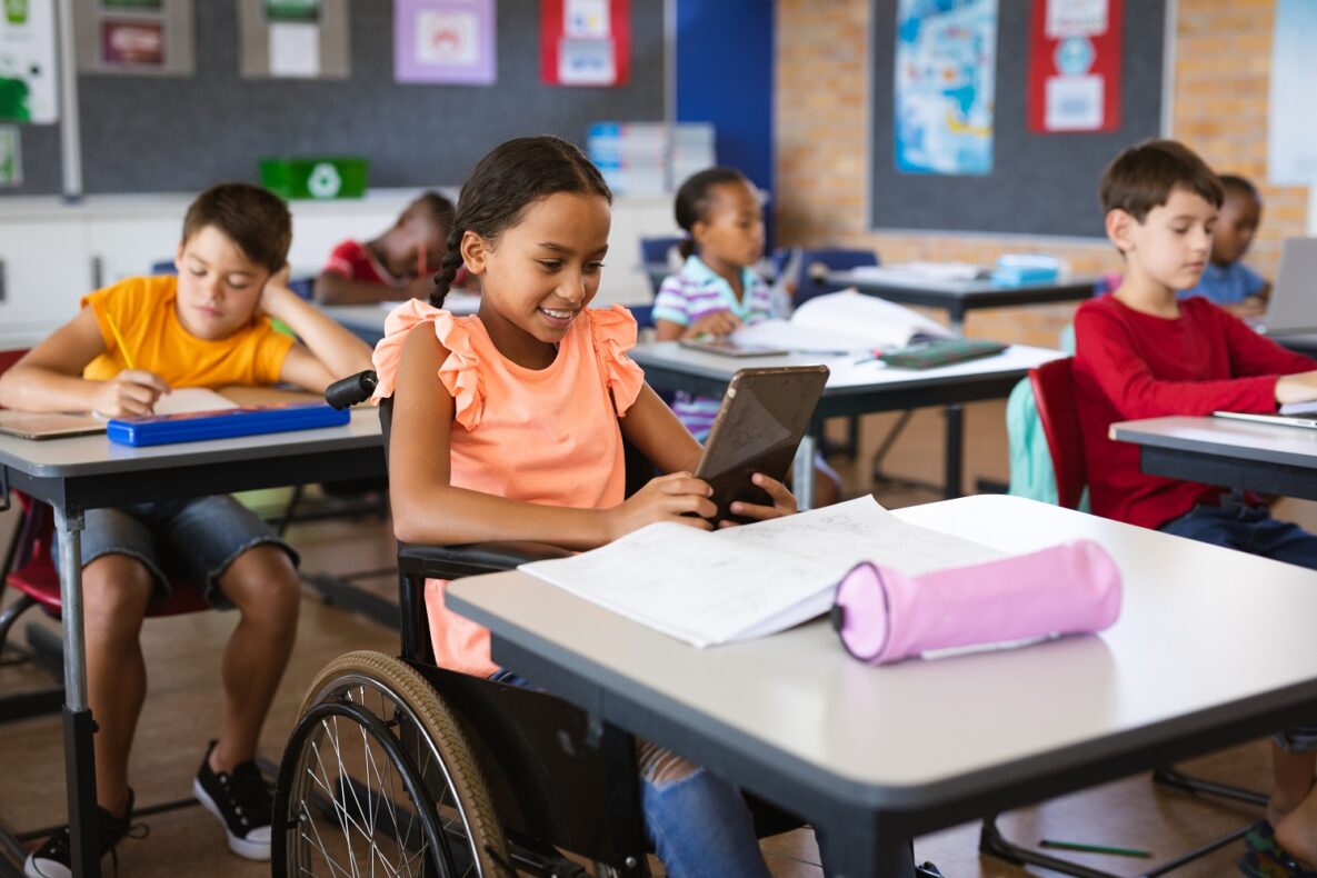 A young girl in a classroom using her iPad.
