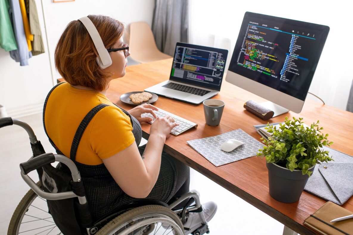 A young woman in a wheelchair using a laptop.