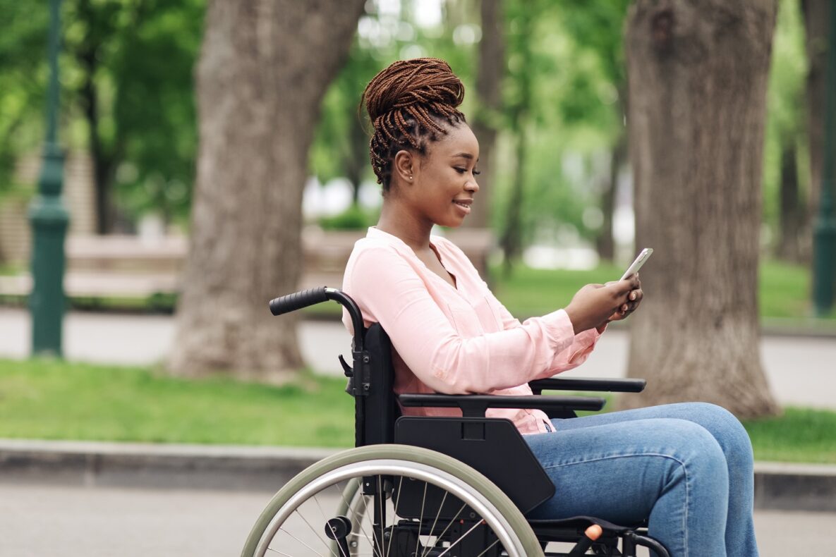 A woman in a wheelchair using her smartphone.