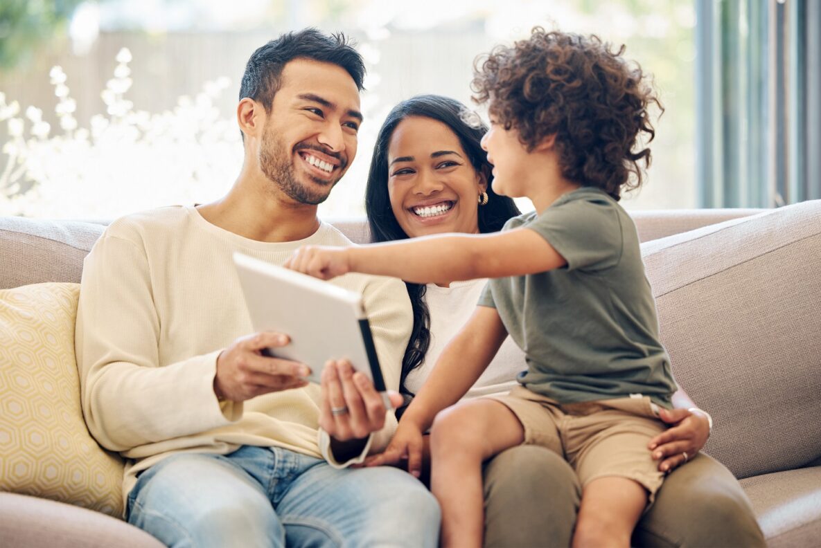 Shot of a little boy using a digital tablet while sitting at home with his parents