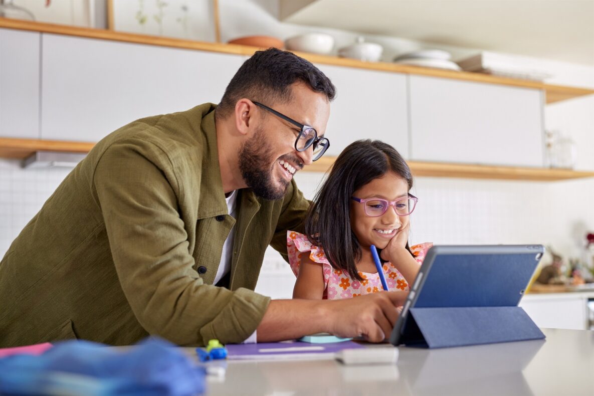 Smiling father helping little girl with study