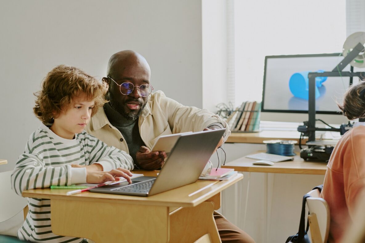 A teacher and a student using a laptop