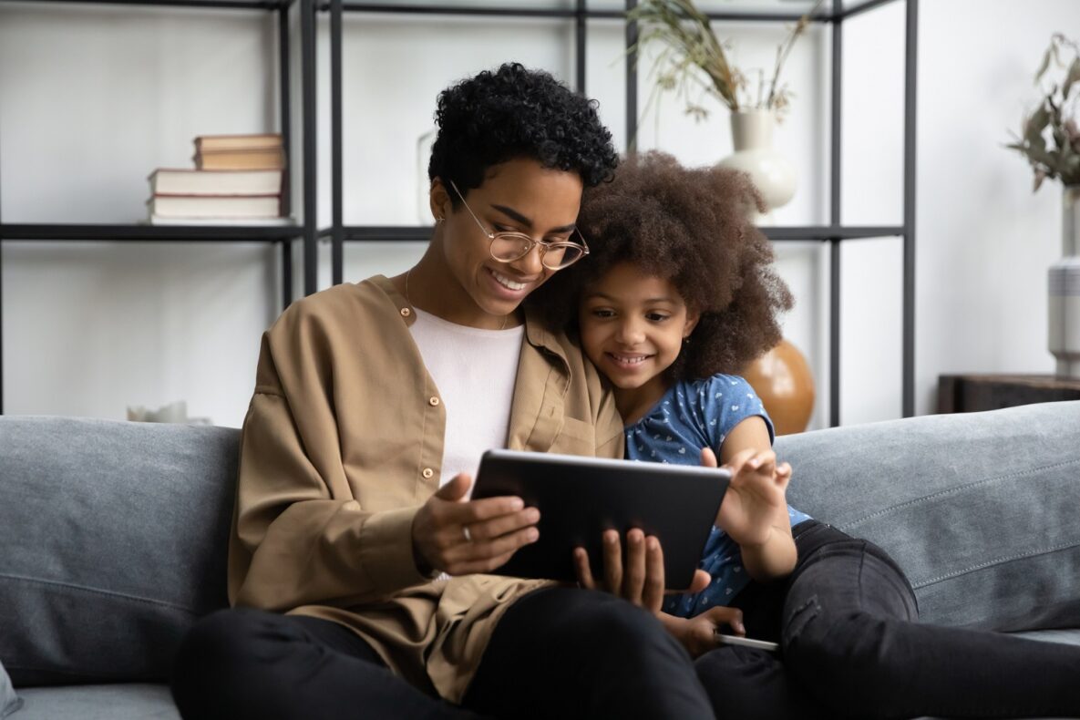 A parent and her child using their tablet